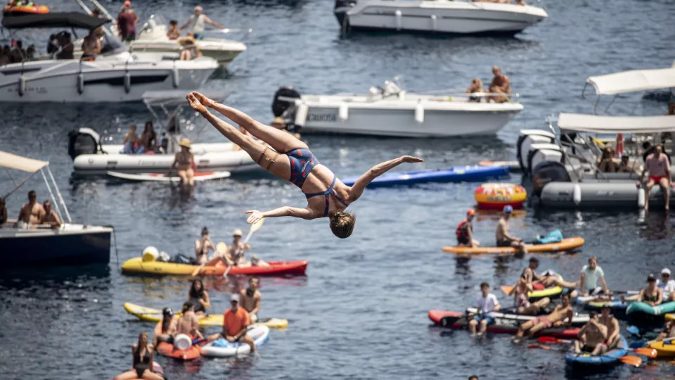 Accrobatie avec les spectateurs sur leurs bateaux en fond
